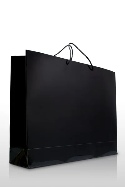 Mão e preto esmalte saco de compras de papel, isolado — Fotografia de Stock