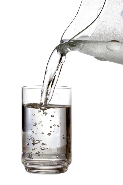Наполнение стакана водой на белом фоне — стоковое фото