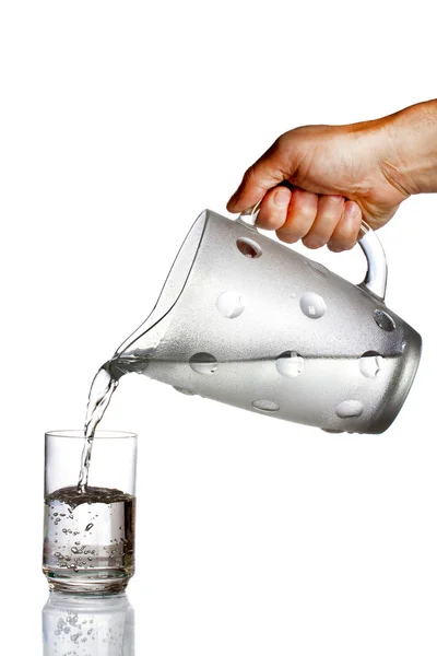 Mano versando acqua dalla brocca di vetro — Foto Stock