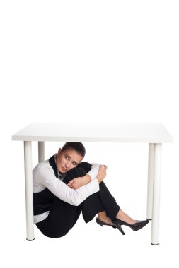 Depressed business woman hiding under a table clipart