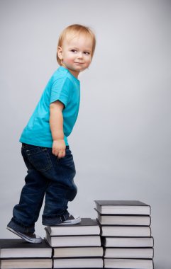 Young man climbing on a ladder of books clipart