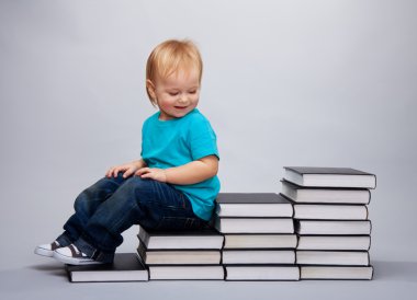 Kid sitting on a a steps made of books clipart