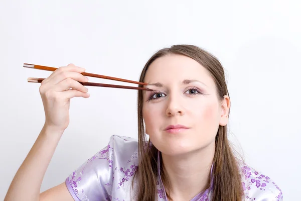 Женщина с палочками для суши — стоковое фото