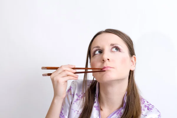 Женщина с палочками для суши — стоковое фото