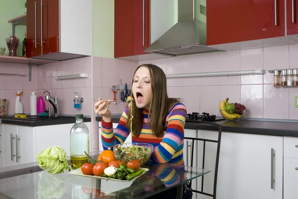 Γυναίκα τρώει σαλάτα στην κουζίνα — Φωτογραφία Αρχείου