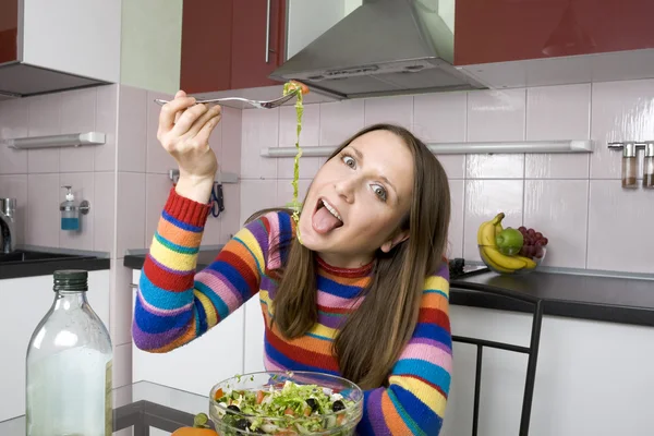 Donna che mangia insalata in cucina — Foto Stock