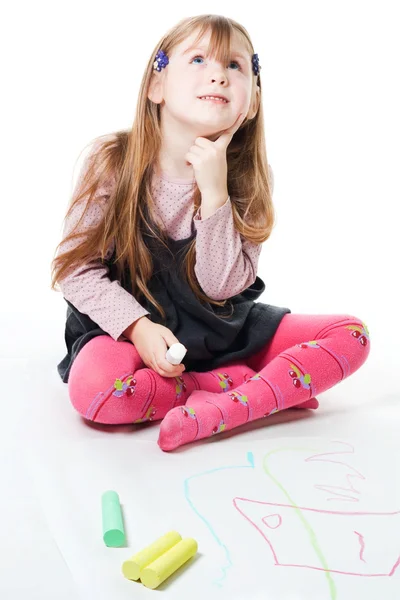 Маленькая девочка думает и рисует — стоковое фото