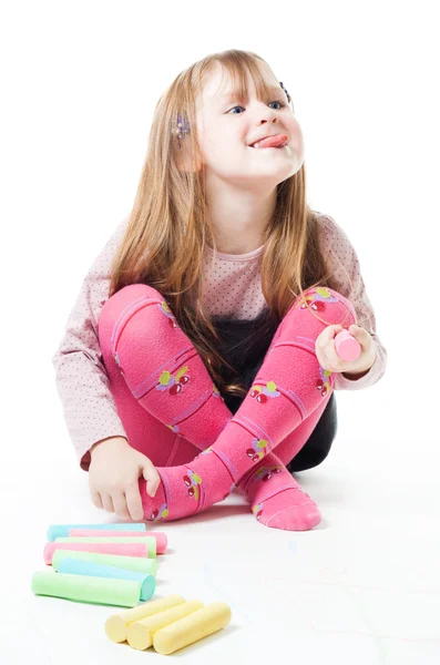 Little girl with chalks stick her tongue out — Stock Photo, Image