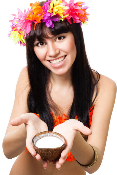 Женщина в костюме цветов предлагает кокосовое молоко
