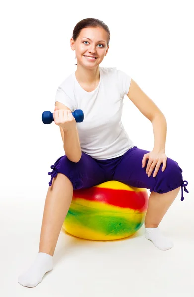 Ung kvinna gör övningar med boll och dummbell — Stockfoto