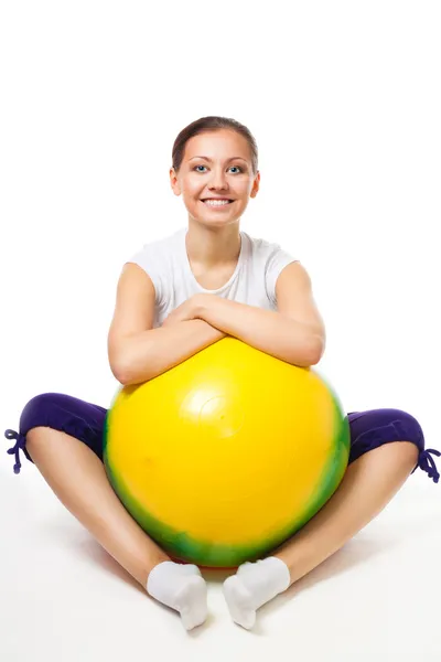 Ευτυχής νεαρή γυναίκα καθίσει με την μπάλα γυμναστικής — Φωτογραφία Αρχείου
