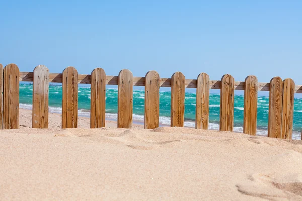 Small wood fence in sand on the coast — Stock Photo, Image