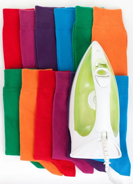 Železo a různé barevné ponožky — Stock fotografie