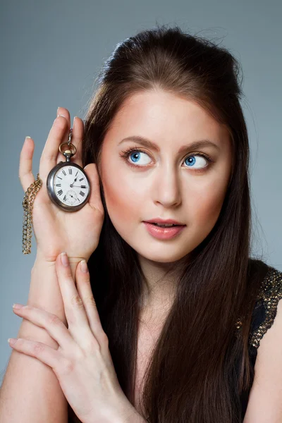 Hermosa mujer escuchar cómo reloj garrapatas — Foto de Stock