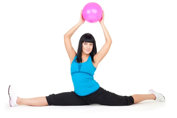 Woman do splits sitting holding ball — Stock Photo, Image