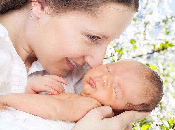 Mutter mit Neugeborenem im Kirschbaumgarten — Stockfoto