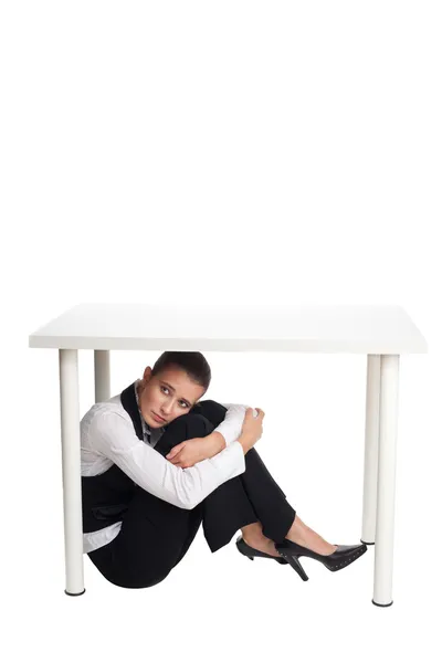 Depressed business woman hiding under a table — Stock Photo, Image