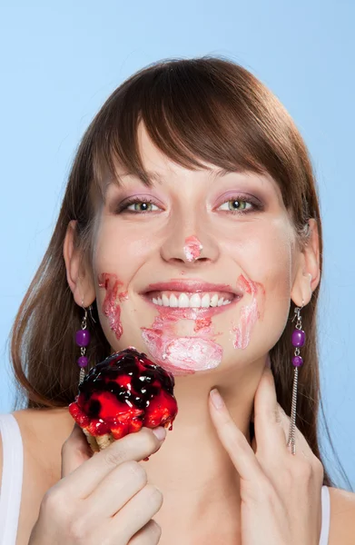 Szczęśliwa dziewczyna z jej twarzy rozmaz w ciasto — Zdjęcie stockowe