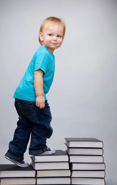 Jovem subindo em uma escada de livros — Fotografia de Stock