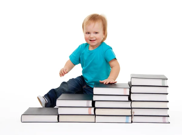 Happy kid sitting on the steps of books — Stock Photo, Image