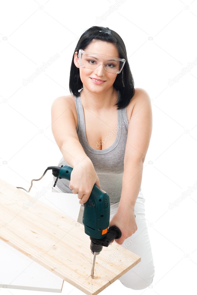 Woman drill hole in wood plank