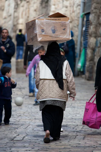 Mulher muçulmana carrega caixa na cabeça — Fotografia de Stock