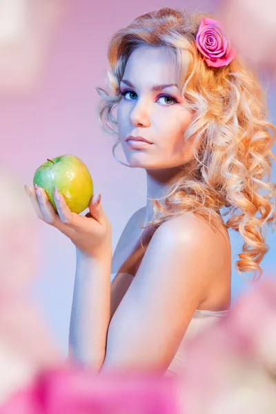 Кудрявая блондинка с зеленым яблоком — стоковое фото