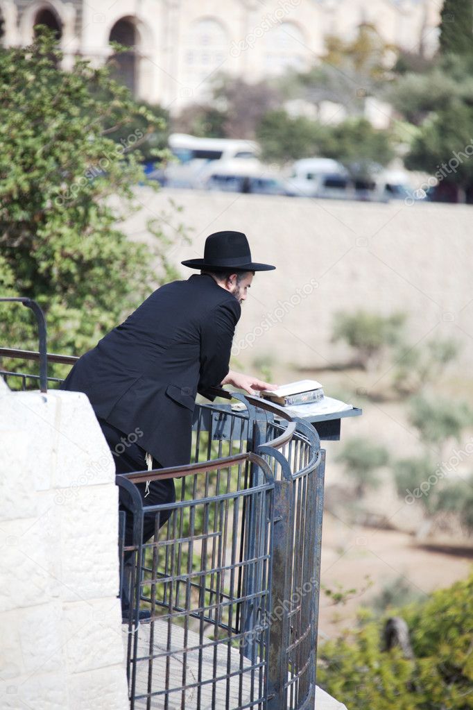 Orthodox Jewish man parrying in front of cemetery in Jerusalem