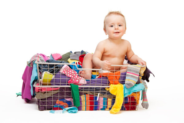Happy baby in basket with clothes