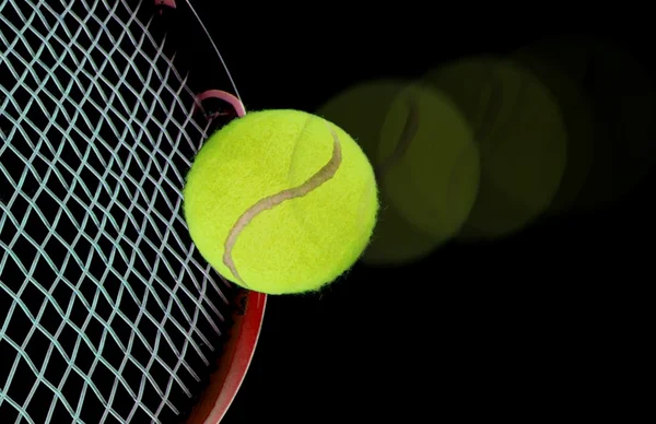 Tenisz labda és az ütő fekete felett — Stock Fotó