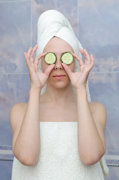 Vrouw met een komkommers op ogen — Stockfoto