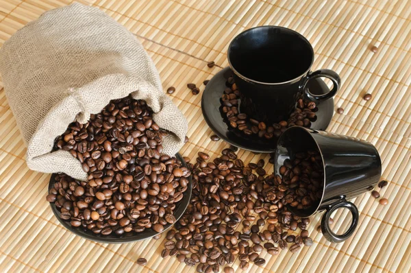 Chicchi di caffè con tazze e sacco — Foto Stock