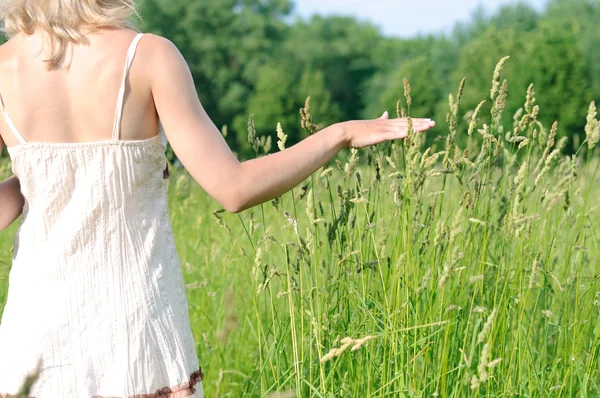 Vrouw aanraken van gras — Stockfoto