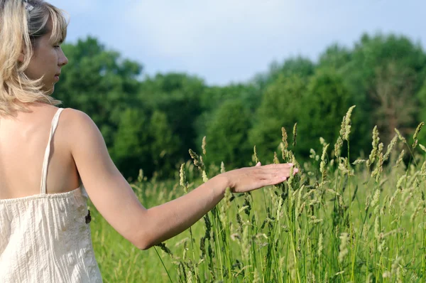 Vrouw aanraken van gras — Stockfoto