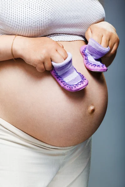 赤ちゃんの靴のペアを保持している女性 — ストック写真