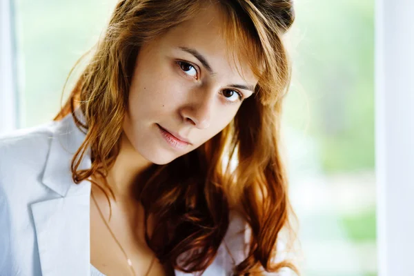 Young casual woman sitting on window — Stock Photo, Image