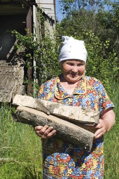 Grandmother with firewood — Stock Photo, Image