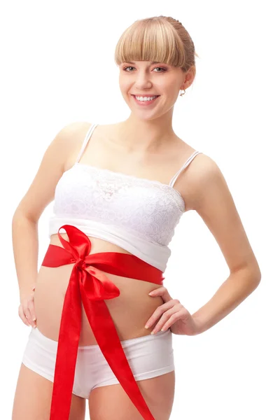 Těhotná žena s červenou mašli na břicho — Stock fotografie