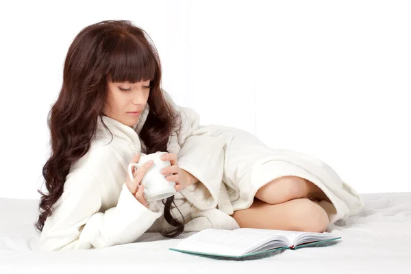 Frau liest Buch auf dem Bett liegend — Stockfoto