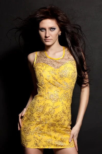Nő pózol, rajta sárga ruhát — Stock Fotó