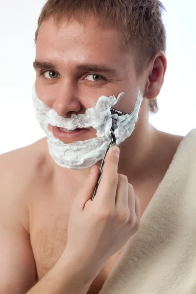 Привлекательный мужчина бреет лицо — стоковое фото