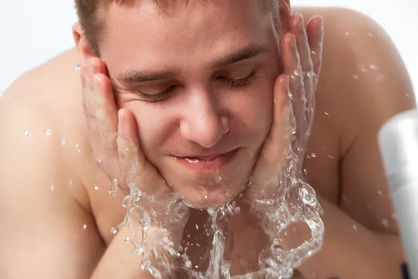 Ο νεαρός πλένει το πρόσωπό του. — Φωτογραφία Αρχείου