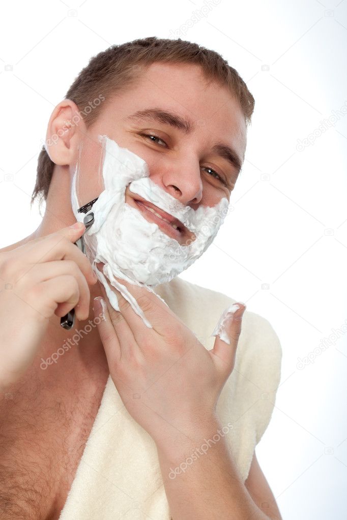 Attractive man shaving his face