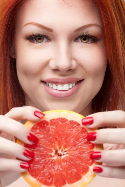 Mujer roja sosteniendo pomelo — Foto de Stock
