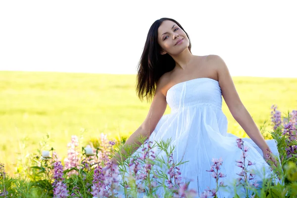 Woman sitting in the flowers — Stock Photo, Image