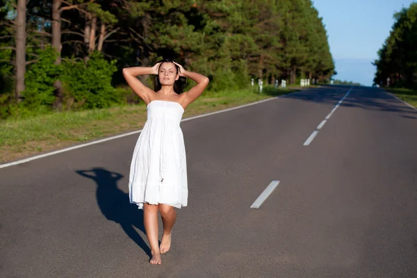 Žena chůze po silnici — Stock fotografie