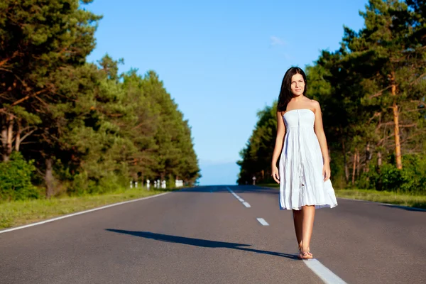 Woman walking along the road — Stock Photo, Image