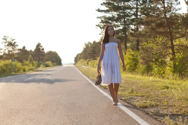Woman walking along the road — Stock Photo, Image