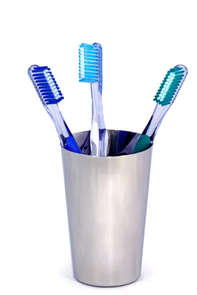 Three toothbrushes in a steel cup — Stock Photo, Image