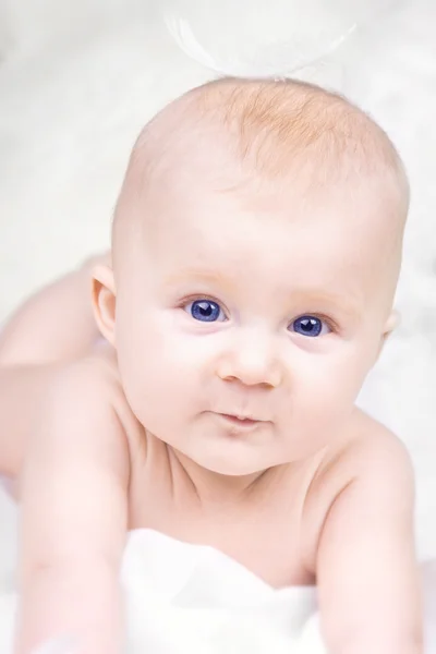 Portrét spokojené miminko s pérem na bílém pozadí — Stock fotografie